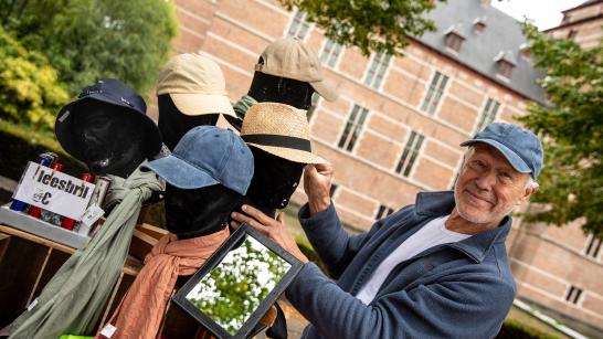 Marktkramer poseert met zijn petten op het Warandeplein