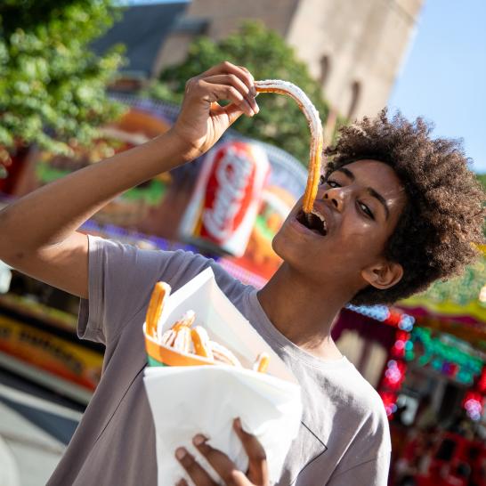 jongen eet churos op kermis