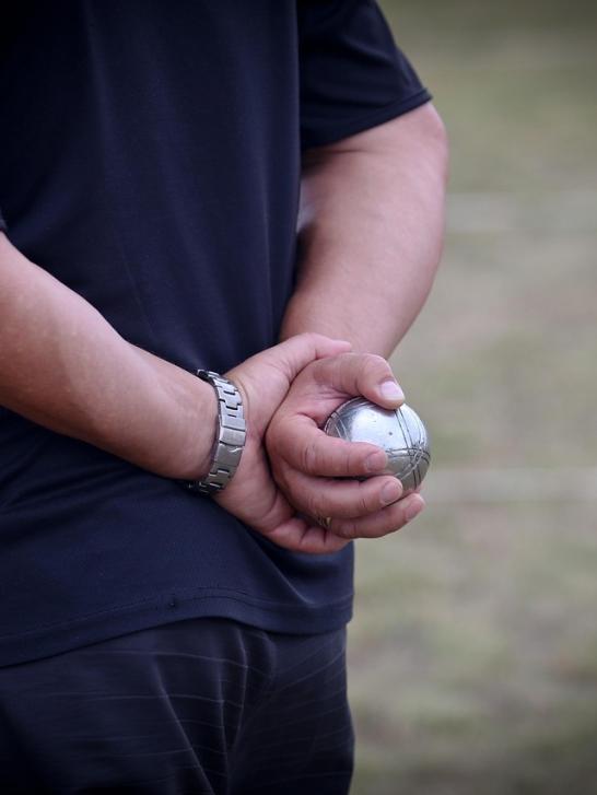 Man heeft petanqueballen vast