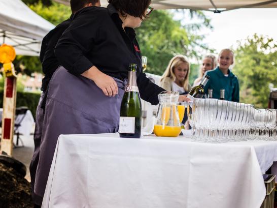 vrouw serveert cava en fruitsap op feest