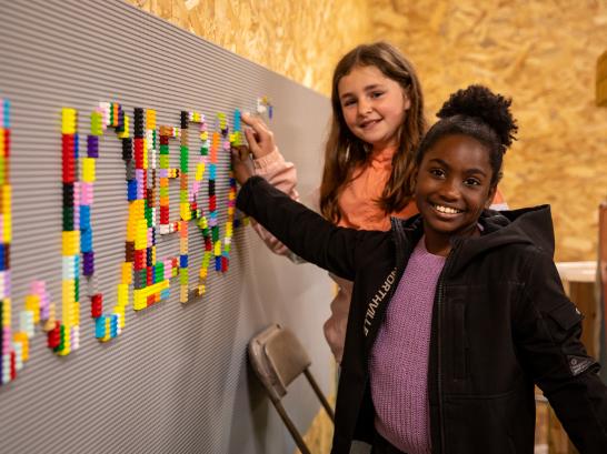 Kinderen maken het woord 'Wollebos' met lego