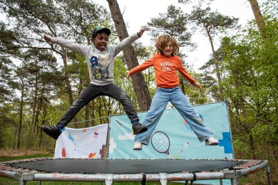 Kinderen springen op trampoline tijdens Wollebos