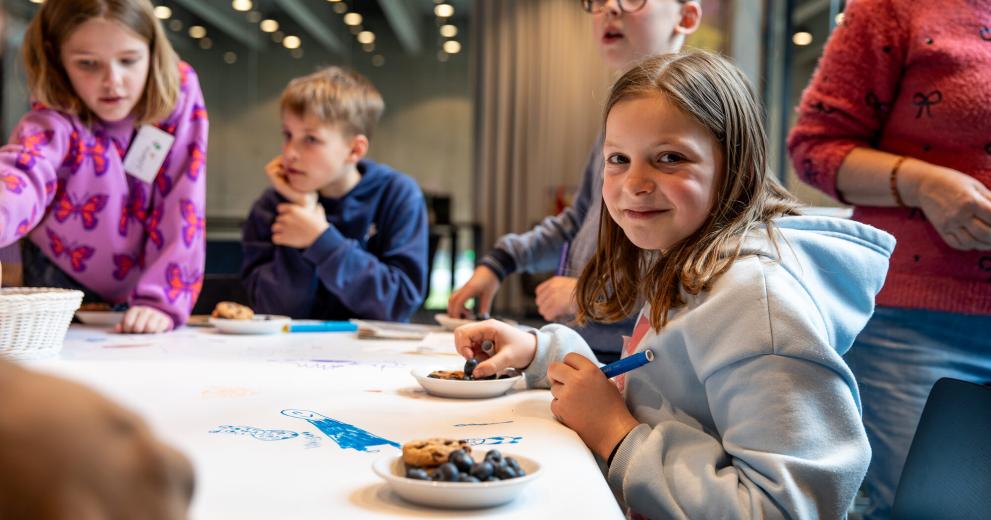 Kind is samen met andere kinderen aan het kleuren