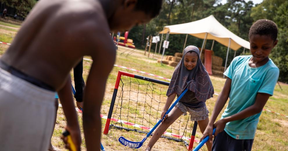 3 kinderen spelen hockey op Wollebos