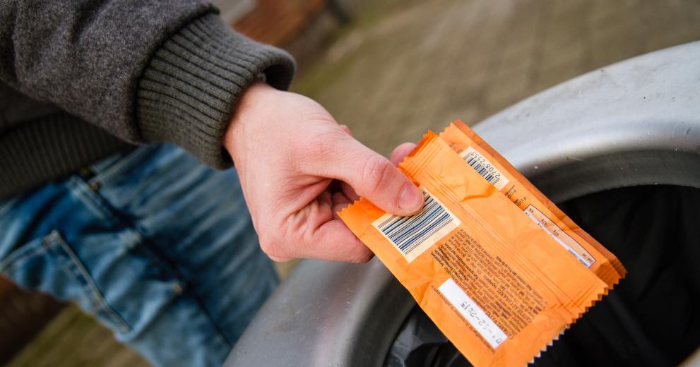 Jongen gooit papiertje in vuilbak
