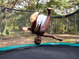 jongen maakt salto op trampoline