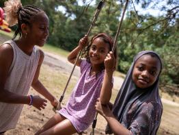3 kinderen spelen op schommel
