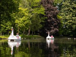 Kinderen en ouders fietsen met waterfietsen op de vijver in het Stadspark