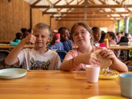 2 kinderen eten boterhammen op Wollebos