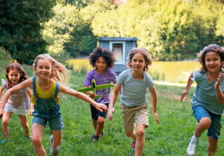Kinderen lopen door gras richting camera