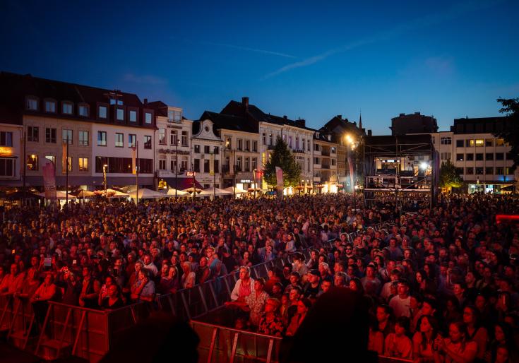 Bezoekers die naar een optreden kijken op de Grote Markt