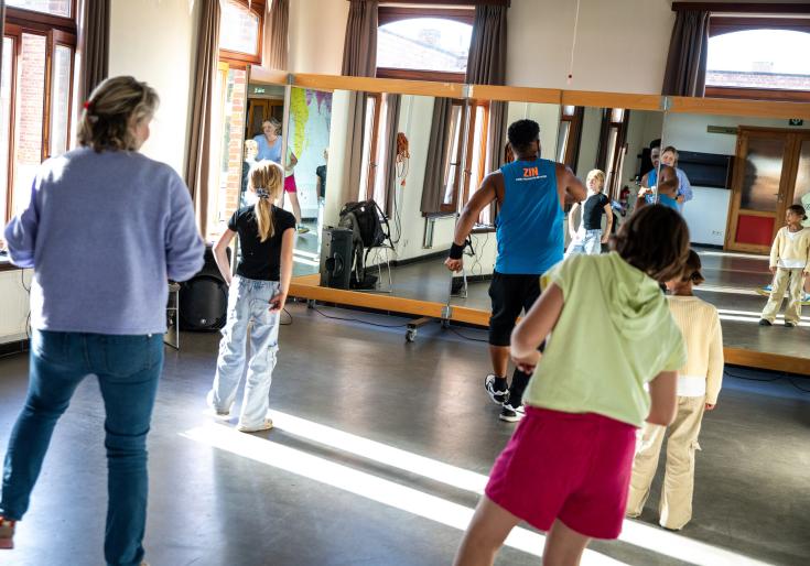 Jongeren volgen dansles in Wollewei