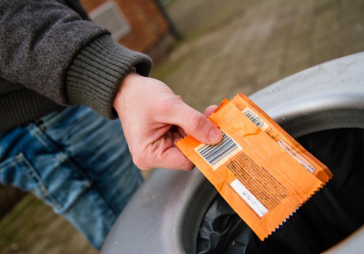 Jongen gooit papiertje in vuilbak