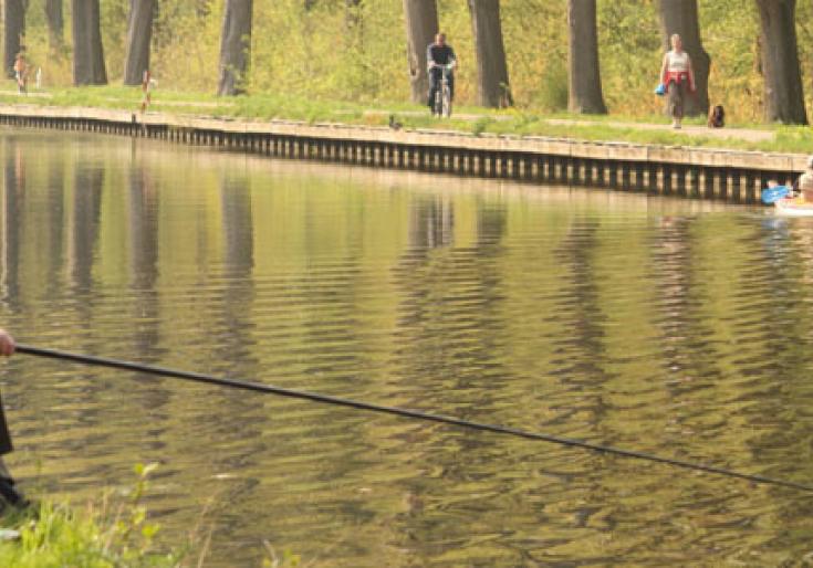 man is aan het vissen aan het kanaal