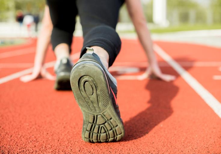 Persoon staat klaar om te lopen op piste, close up voeten